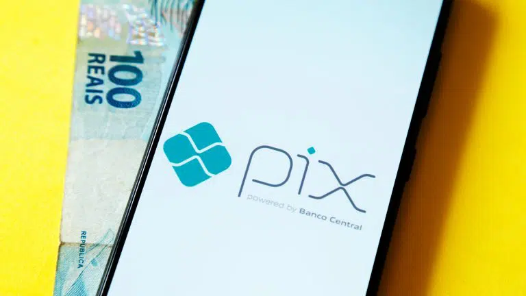 Celular com tela do PIX e nota de R$ 100 do Real brasileiro